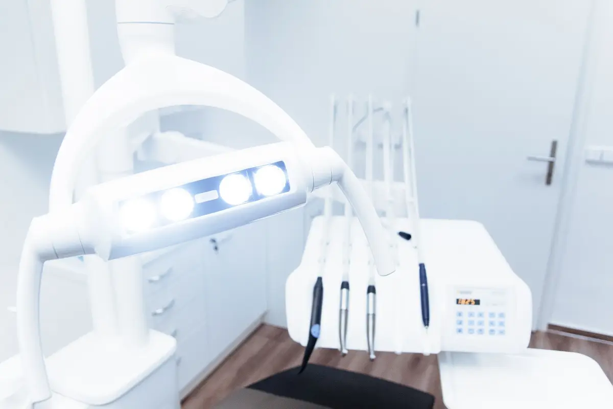 A bright dental treatment room with the operatory light and instruments in view