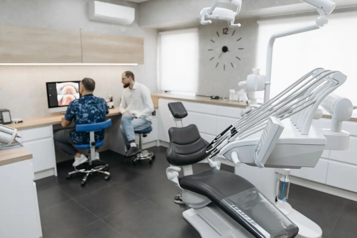 Two members of a dental team reviewing images on a screen in a modern clinic